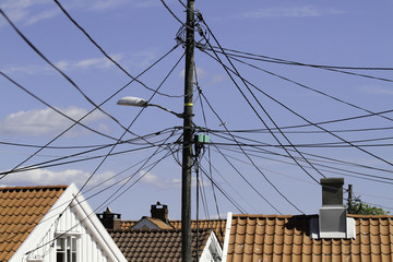 Kabelwirrwarr an einem Mast - gefährliches Chaos über den Dächern.
