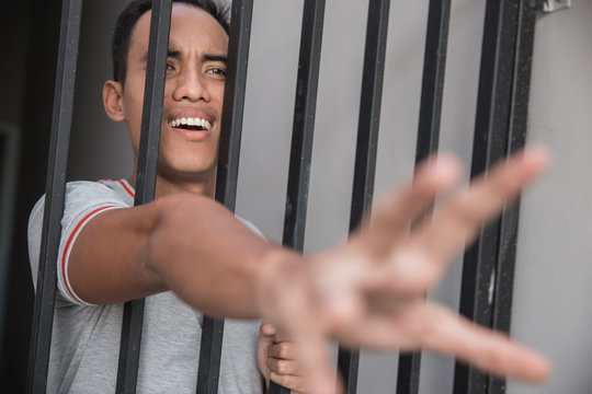 man in jail behind bars