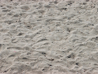 Dirty Beach Sand with little rocks, foot, and shoe prints