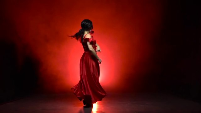 Dancer an incendiary dance of Argentine flamenco . Llight from behind. Smoke background. Slow motion