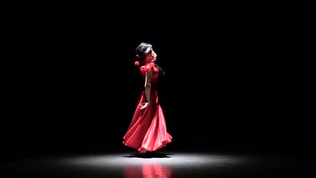 Flamenco. Dancer performs elegant movements with her hands in sexual dance. Black background. Slow motion