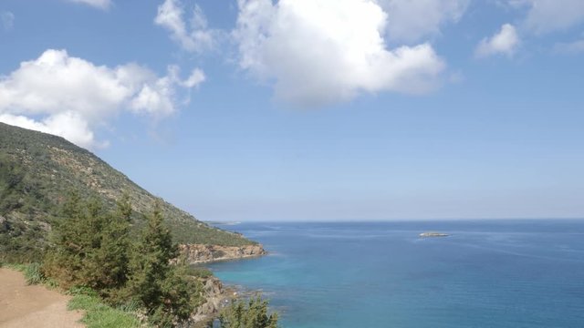 Beautiful view of Ayla Napa with mountains on the left and sea on the right with fluffy white clouds in the blue sky