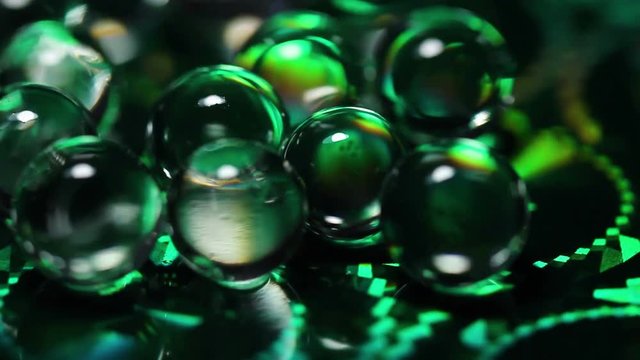 Hydrogel balls on holographic surface. Close up macro footage.
