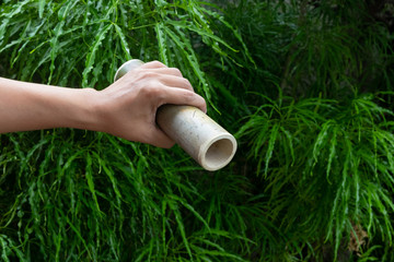 Bamboo tube in the hand of man