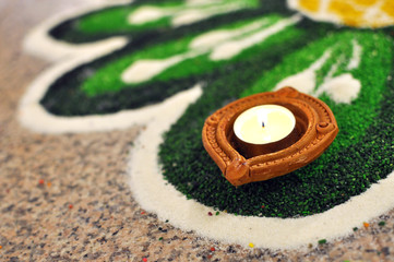 Hindu Deepavali Oil lamp lit and placed on decorated Green kolam, Indian Community Cultural practice