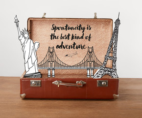 Open vintage travel bag with illustration and lettering - Spontaneity is the best kind of adventure