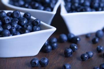 Pick blueberries in a white porcelain bowl. A large number of blue bilberries. Organic blueberries in a mug for healthy eating 