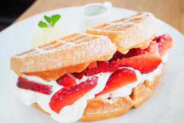 Delicious strawberry waffle whipped cream topping dish with vanilla ice-cream and honey sauce