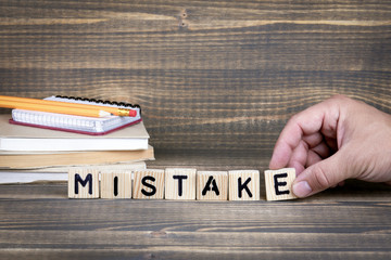 Mistake. Wooden letters on the office desk, informative and communication background