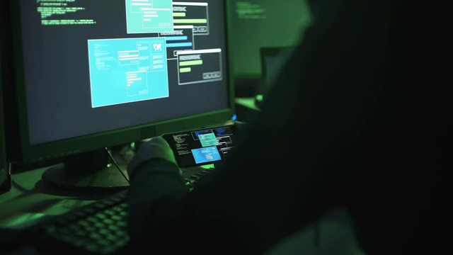 Professional hacker working with multiple devices