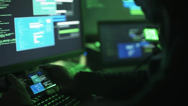 Professional hacker working with multiple devices