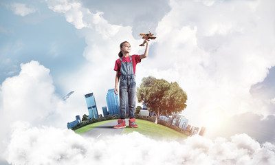 Concept of careless happy childhood with girl dreaming to become
