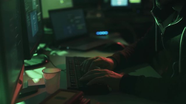 Black hat hacker working in his basement late at night
