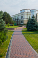 a luxurious lawn in the park and a winding path between them to the building