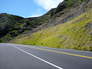 Fototapeta premium Empty Road along a lush green mountain