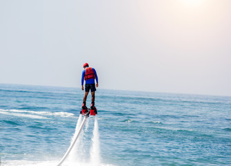 Man posing at new flyboard at sea. Positive human emotions, feelings, vacations and enjoying summer.