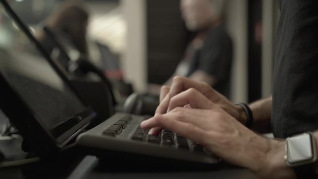 Typing On Computer Keyboard in a shop counter environment.