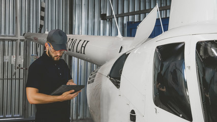 Male mechanic in uniform examining helicopter. Pre flight inspection at the airportы © supamotion