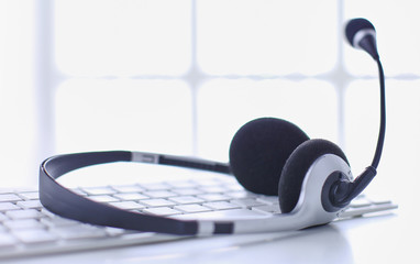 Communication support, call center and customer service help desk. VOIP headset on laptop computer keyboard