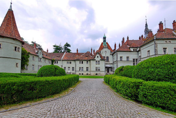 Ancient medieval castle with a red roof on a green park background