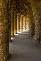 Arcade of masonry stone columns in Park Guell, Barcelona designed by Antoni Gaudi. Travel destination, tourism attraction, guided tour visit concepts