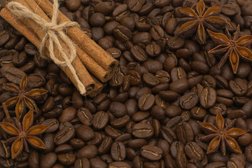 Background of coffee beans. Coffee texture. Cinnamon sticks and cardamom.