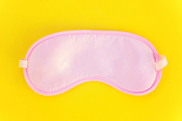 Sleeping eye mask, isolated on yellow colourful trendy background. Do not disturb me, let me sleep. Rest, good night, insomnia, relaxation, tired, travel concept