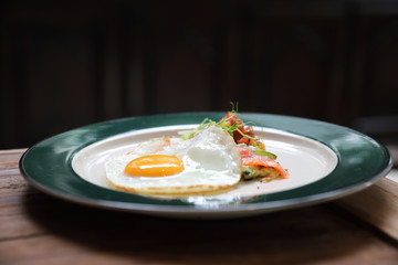 Zucchini fritters with egg and smoked salmon on wood background vinage style