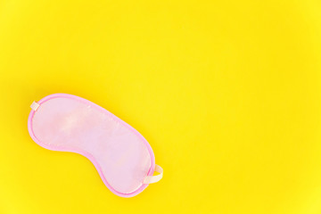 Sleeping eye mask, isolated on yellow colourful trendy background. Do not disturb me, let me sleep. Rest, good night, insomnia, relaxation, tired, travel concept