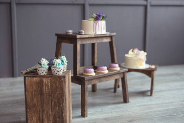cakes and macaroons on wooden chair on a dark background