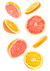 Fototapeta na wymiar sliced flying grapefruit and orange falling isolated on white background