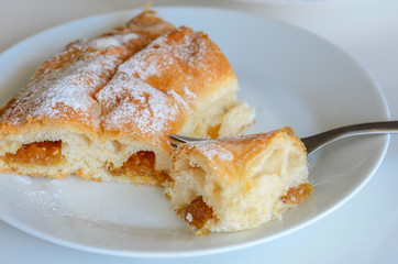 Piece of Ensaimada,  coil-shaped flaky pastry  from Mallorca,  Balearic Islands. This is one of popular pastries in Spain eating at breakfast, snack time and dessert