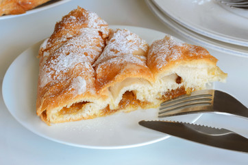 Piece of Ensaimada,  coil-shaped flaky pastry  from Mallorca,  Balearic Islands. This is one of popular pastries in Spain eating at breakfast, snack time and dessert