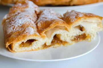 Piece of Ensaimada,  coil-shaped flaky pastry  from Mallorca,  Balearic Islands. This is one of popular pastries in Spain eating at breakfast, snack time and dessert