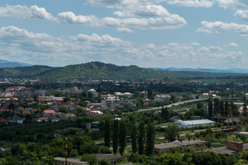 A small town is located at the foot of a long ridge of green mountains