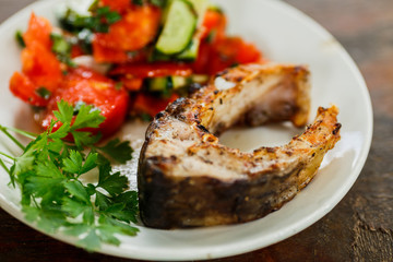 fried piece of fish and salad on a white plate