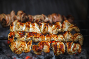 meat is roasted on the fire in the grill