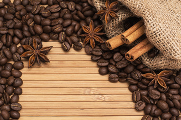 Background of coffee beans. Coffee texture. A place to write a text. Cinnamon sticks and cardamom.