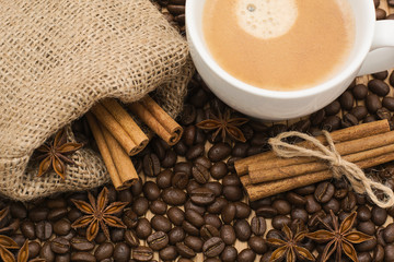A cup of latte coffee and coffee beans.