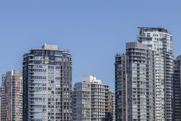 Fototapeta na wymiar The Top of Several Buildings against a Blue Sky