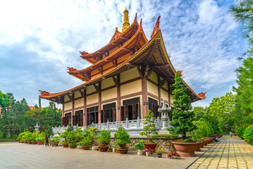 Naklejka premium Ho Chi Minh City, Vietnam - May 29, 2018: Architecture temple in morning Buddha's birthday decorated flowers, flags, front yard attracted Buddhists visit cultural spiritual in Ho Chi Minh, Vietnam