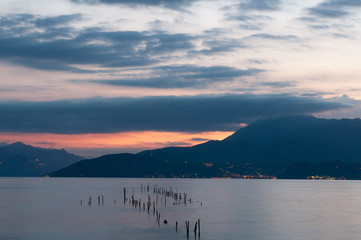 Sunrise on the lake. Early morning landscape. mountain in  silhouettes and the rays of the rising sun.Sunrise on Lake Garda, Italy.