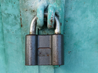 Black padlock on the locked metal doors. Home security concept