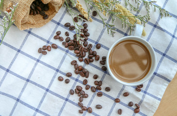 Top view coffee in a white cup with coffee beans