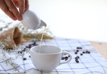 Woman hand pouring tea to the white cup