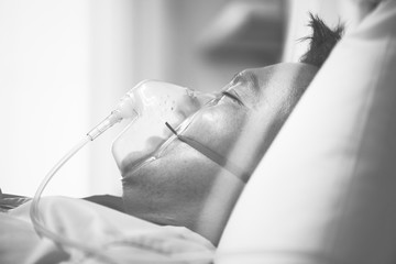 A sick Asian man wearing an oxygen mask