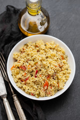 tabbouleh in white bowl on black ceramic background