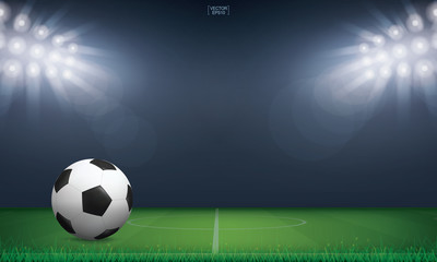 Naklejka premium Soccer football ball on green grass of soccer field or football field stadium background. Vector.