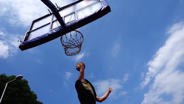 Street basketball. The player scores the ball in the basket.Slow-motion shooting of 240 frames per second