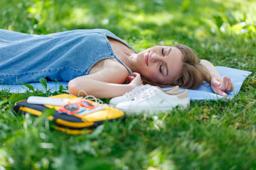 Pretty young woman relaxing on the grass in a park. Top view